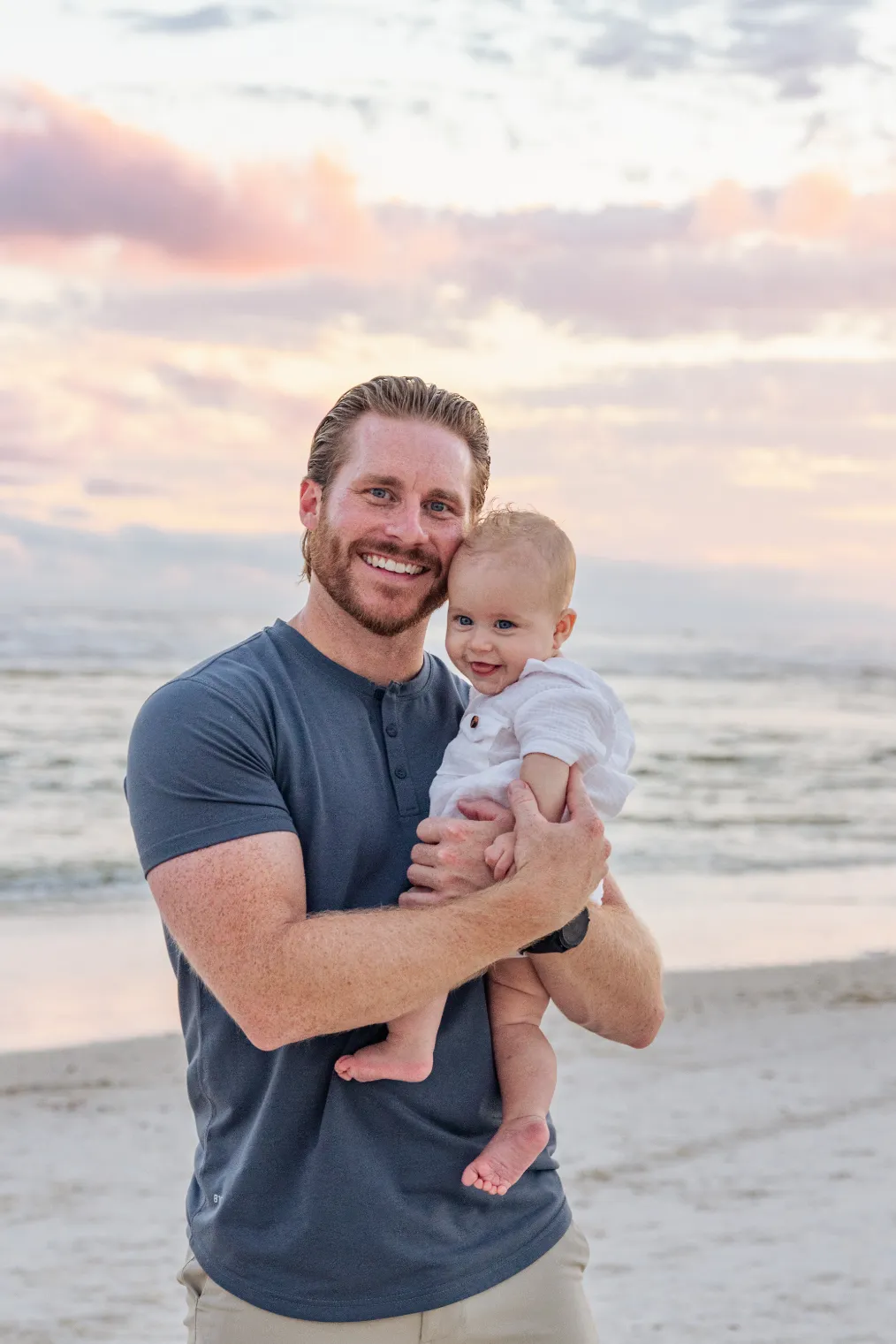 A photo of a dad holding his son during a Gulf Shores family beach photoshoot.