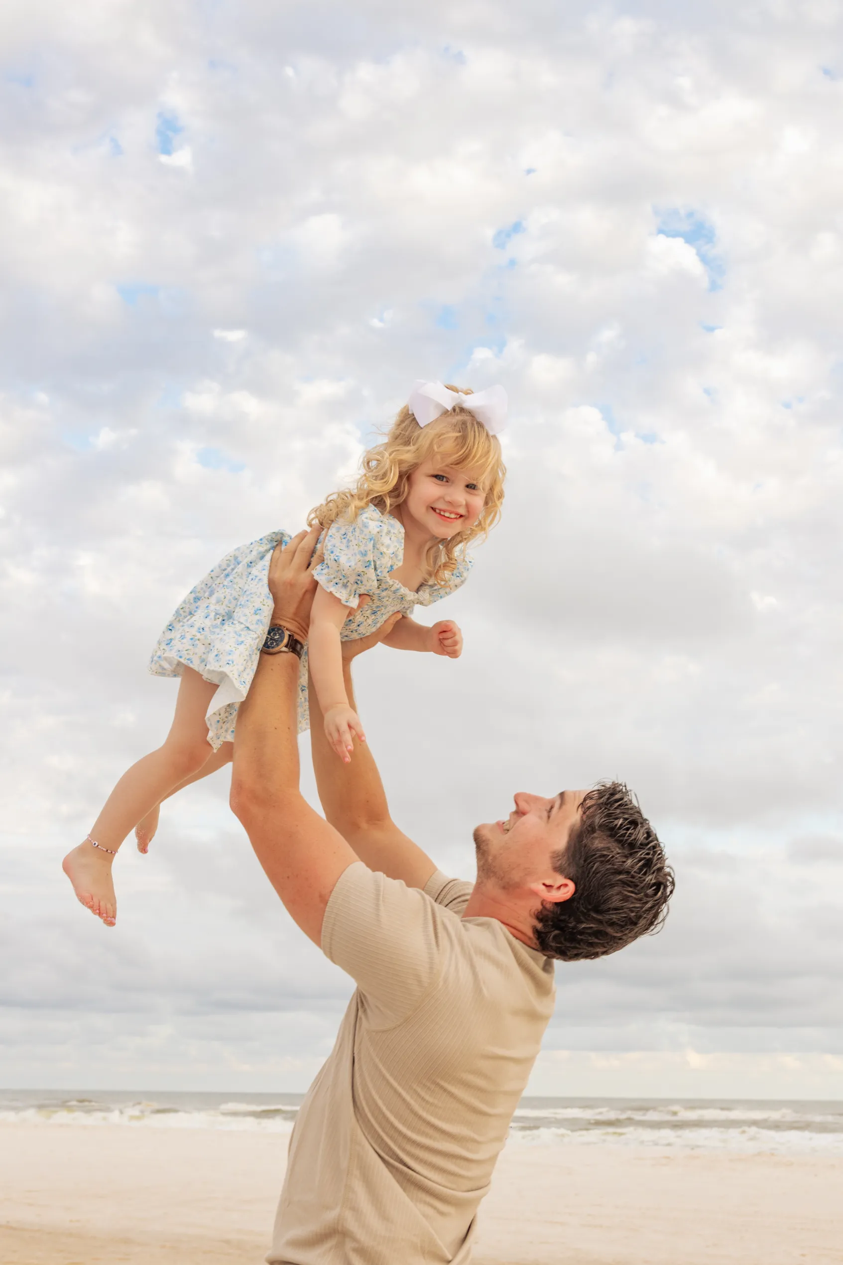 Dad holding his daughter up in the sky during a Gulf Shores family beach photoshoot.