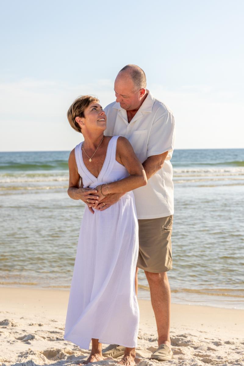 Anniversary photoshoot in Gulf Shores, Alabama. A man holding his wife on the beach. Gulf Shores anniversary photographer