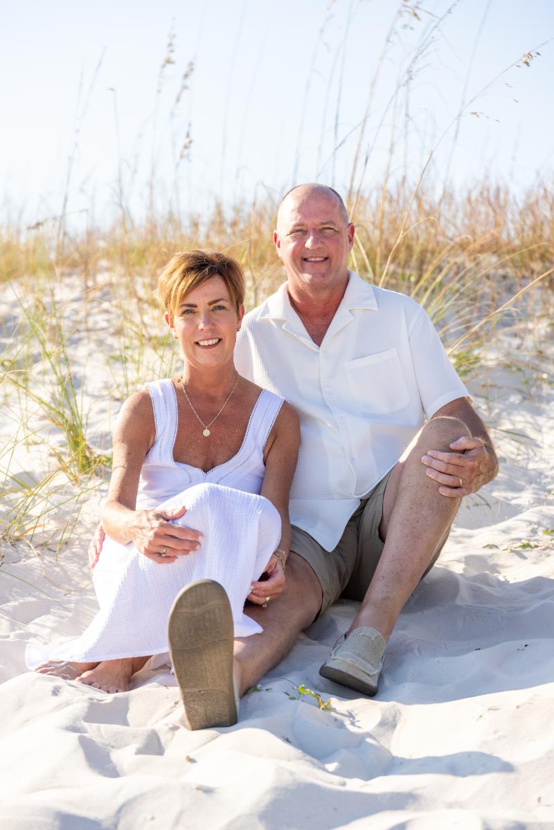 Anniversary photoshoot in Gulf Shores, Alabama. A married couple sitting on a sand dune. Gulf Shores anniversary photographer